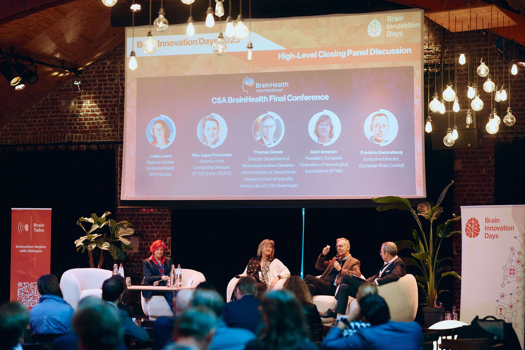 People sitting on stage and discussing in front of an audience